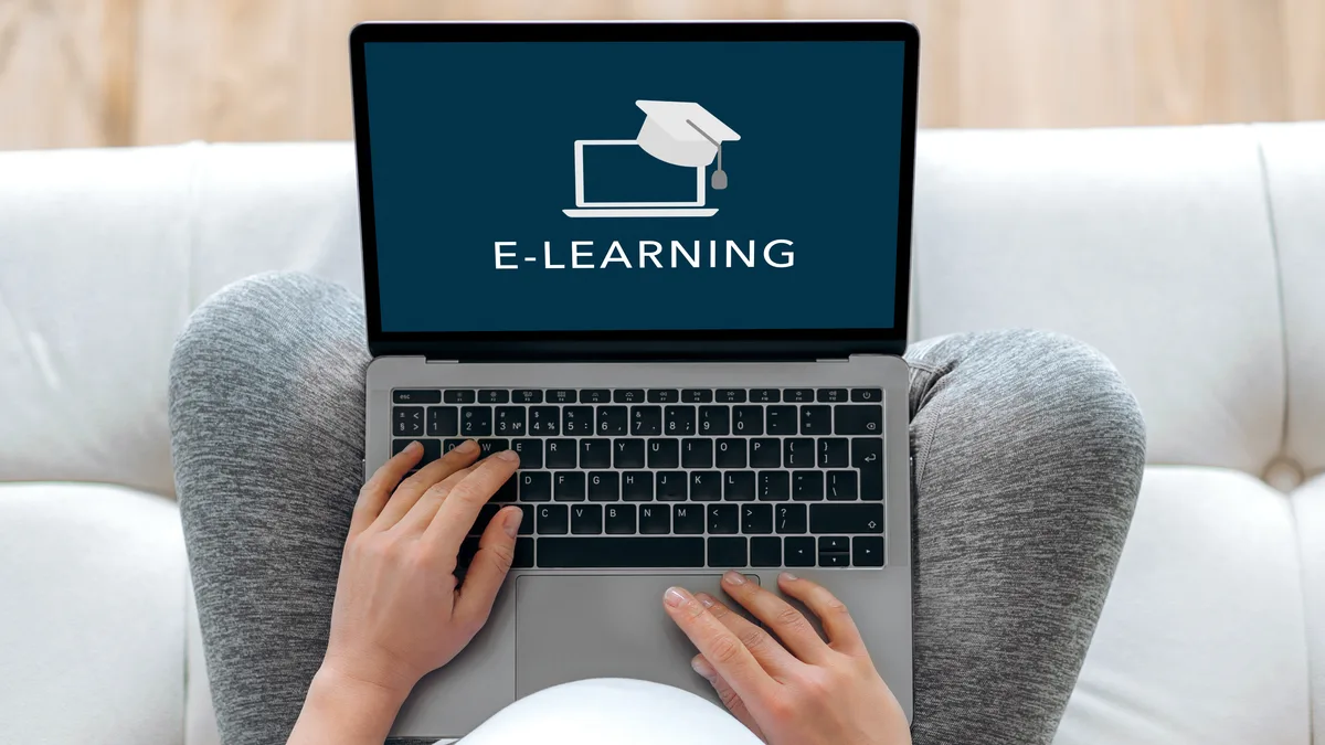 Persona usando una laptop con la palabra E-LEARNING en la pantalla